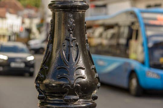 Bottom of old lamppost with blurred city life in background, shallow depth of field, autumn season 2021