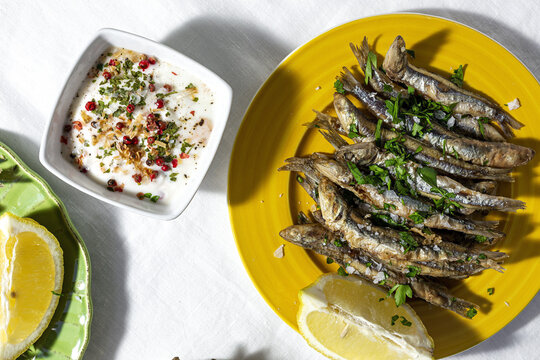 Grilled anchovies served on table and white soup