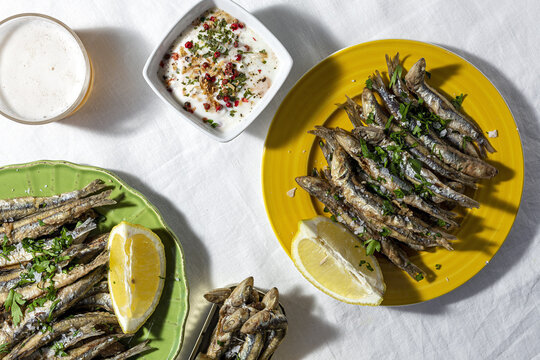 Grilled anchovies served on table with beer glass and white soup