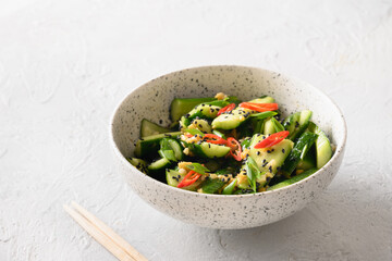 Asian spicy salad Broken Cucumbers with fresh coriander, ginger, pepper chili, black vinegar on white background. Popular Chinese cold appetizer. Close up.