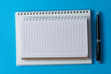 Top view of blank open notebook on blue background and different objects. Minimal flat lay style.