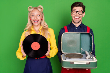 Photo of shocked beautiful young guy lady wear pin up clothes holding vinyl player disk isolated green color background - Powered by Adobe