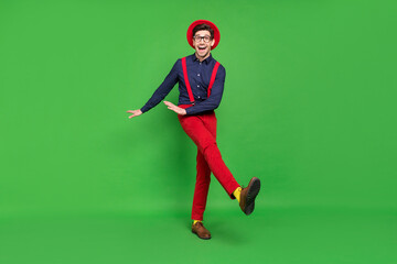 Full body photo of young cheerful guy have fun dance party holiday isolated over green color background