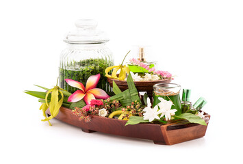 Perfume from fragrant flowers such as ylang-ylang flower, rose, jasmine and pandanus green leaves isolated on white background.