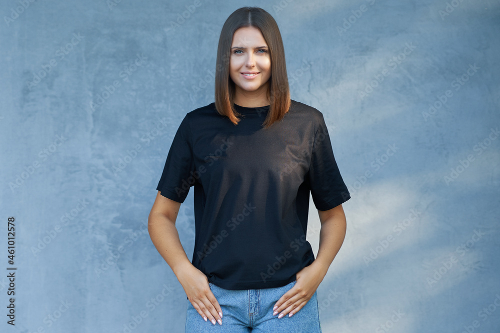 Wall mural Young woman in black shirt