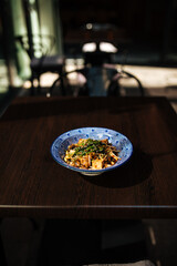 Japanese tofu salad with mushrooms on restaurant table