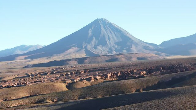 Aerial pull away shot of the volcano Volcan Licancabur east of the town San Pedro de Atacama in the north of Chile in the Atacama desert at sunrise