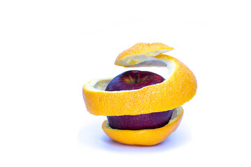 red apple in orange peel spiral on white background