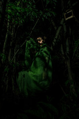 Girl posing in green draping in trees