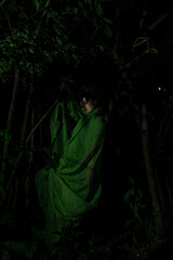 Girl posing in green draping in trees
