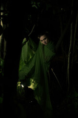 Girl posing in green draping in trees