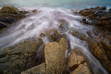 trace of sea water between rocks with sharp edges and silk effect, Blanes, Catalonia, Spain