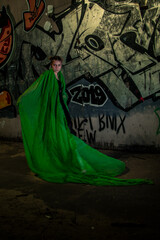 Girl posing in green draping on dark background