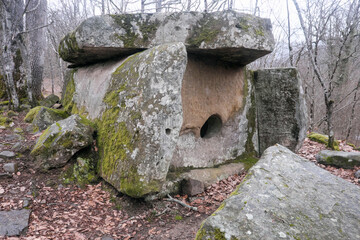 Fototapeta na wymiar View of ancient dolmen in Pshada river gorge on cloudy winter day. Krasnodar Krai, Caucasus, Russia.