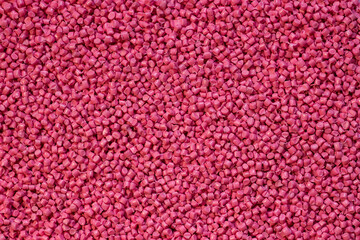 Pink granules of polypropylene or polyamide. Plastics and polymers industry. Copy space.