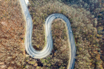 Drone view of mountain road between Vozrozhdenie and Mikhaylovsky Pereval villages on sunny winter day. Krasnodar Krai, Russia.
