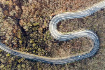 Aerial view of mountain road between Vozrozhdenie and Mikhaylovsky Pereval villages on sunny winter day. Krasnodar Krai, Russia.