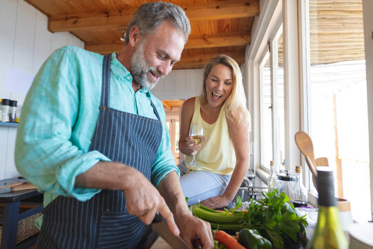 Happy caucasian mature couple cooking together in the modern kitchen