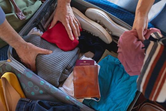 Closeup on a documents and passports and suitcase packing by caucasian couple
