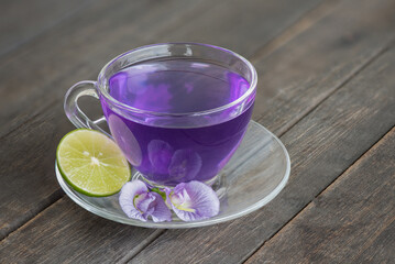 Butterfly pea or Clitoria ternatea flowers juices on an old wood background.