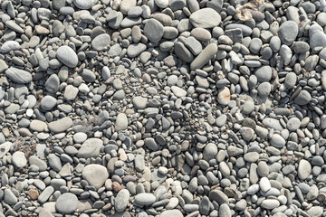 Round pebble stones on the sand on the Black Sea coast in Crimea