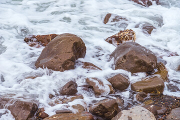 Brown stones washed by the sea - the Black sea of Crimea
