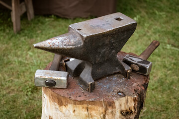 anvil and hammer on a wooden block in the forge