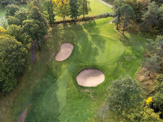 Aerial view of a golf cart with fairways, bunkers and putting greens. Photography taken from above with a drone in Partille in Sweden. Copy space and place for text.