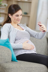 pregnant woman taking selfie on smartphone