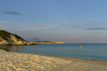 Sea shore with sea mountain view and man surfing on sup board on sunny day. High quality photo