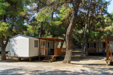 Vacation mobile houses on a campsite with trees around. High quality photo - obrazy, fototapety, plakaty