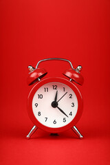 Close up one red alarm clock over red background