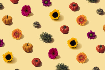Autumn sunlit yellow background with orange pumpkins, sunflower and bright seasonal flowers. Flat lay harvest or halloween concept. Creative layout of colorful vegetables. Copy space.