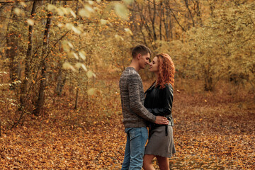 A young couple in love in the autumn forest