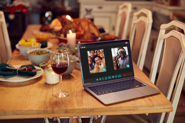 Fototapeta na wymiar Close-up of African American family greeting during video call over laptop on Christmas.