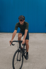 Happy sportsman riding bike alone at urban area