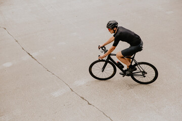 Man in sport clothes having training on bike outdoors