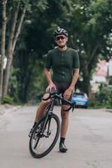 Naklejka premium Man in sportswear smiling on camera while sitting on bike