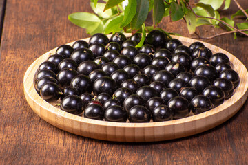 Jabuticaba, Jabuticabas freshly harvested in pots and baskets arranged on rustic wood, selective focus.