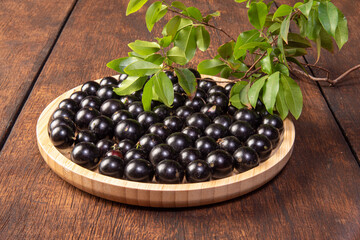 Jabuticaba, Jabuticabas freshly harvested in pots and baskets arranged on rustic wood, selective focus.