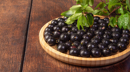 Jabuticaba, Jabuticabas freshly harvested in pots and baskets arranged on rustic wood, selective focus.