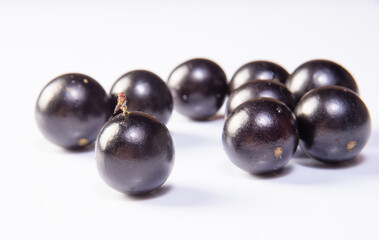 Jabuticaba, Freshly harvested Jabuticabas arranged over white background, selective focus.