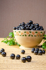 Jabuticaba, Jabuticaba freshly harvested and not yet washed, and branches with leaves placed in a beautiful crockery bowl on a straw mat, selective focus.