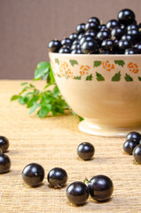 Jabuticaba, Jabuticaba freshly harvested and not yet washed, and branches with leaves placed in a beautiful crockery bowl on a straw mat, selective focus.