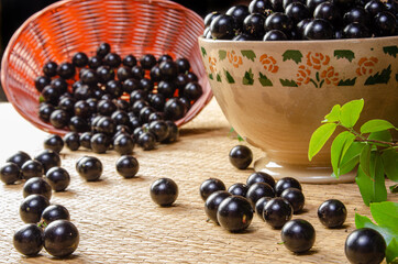 Jabuticaba, Jabuticabas freshly harvested in a bowl and baskets arranged on a straw mat, selective focus.