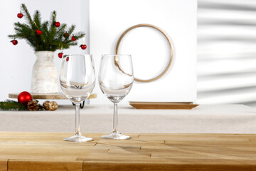 Wooden table with blank and golden Christmas accessories on the background of the wall with a shadow 