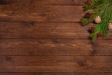 Minimal Christmas composition. Spruce branches with cones, on dark, wooden  background. Christmas, winter concept. Flat lay, top view.