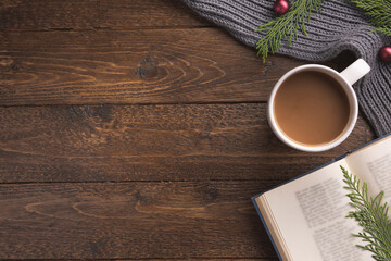 Christmas background with book, cup of coffee and decorations. Holiday decor concept. Overhead, flat lay, top view, copy space