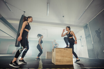 Fototapeta premium Fitness group of strong women having cross-functional training in the gym