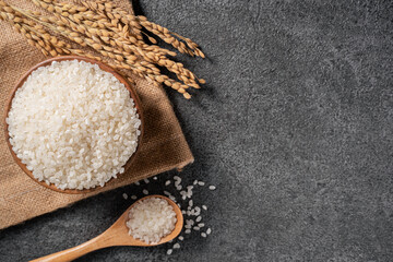White rice in a bowl on dark black table background.